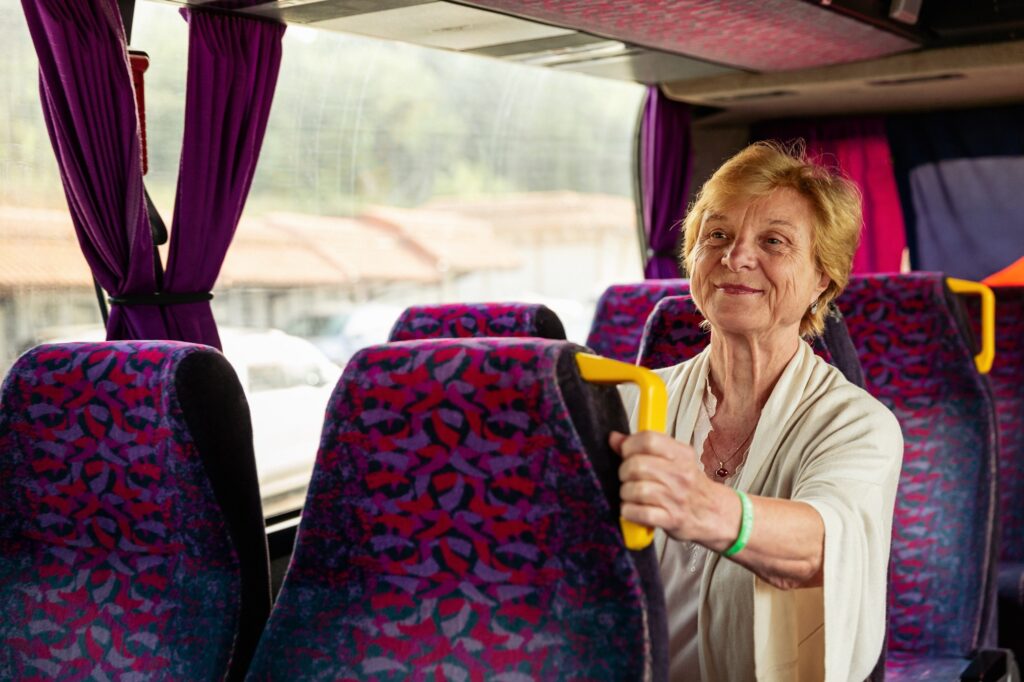 Senior Woman sitting on travel Bus and waiting for excursion.